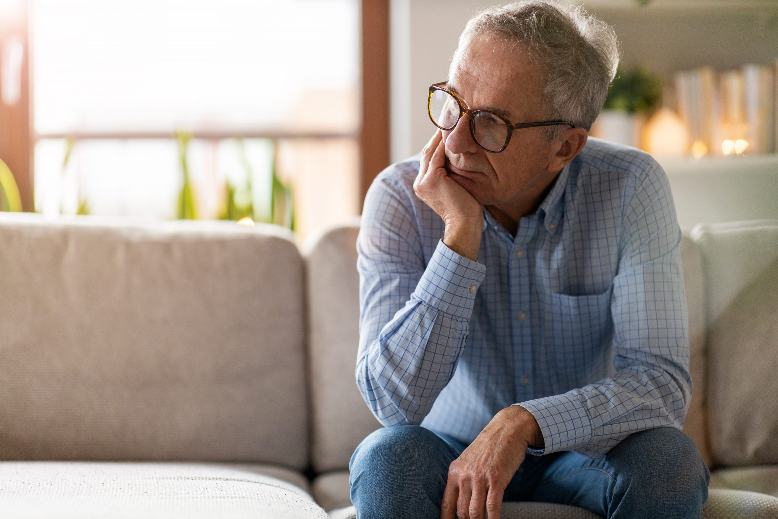 Senior man sitting alone in his home